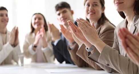 Photo of People applauding at table in office, closeup