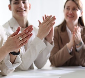 Photo of People applauding at table in office, closeup