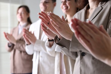 People applauding during meeting indoors, closeup view