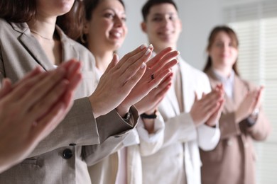 Photo of People applauding during meeting indoors, closeup view