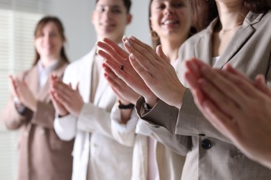 People applauding during meeting indoors, closeup view