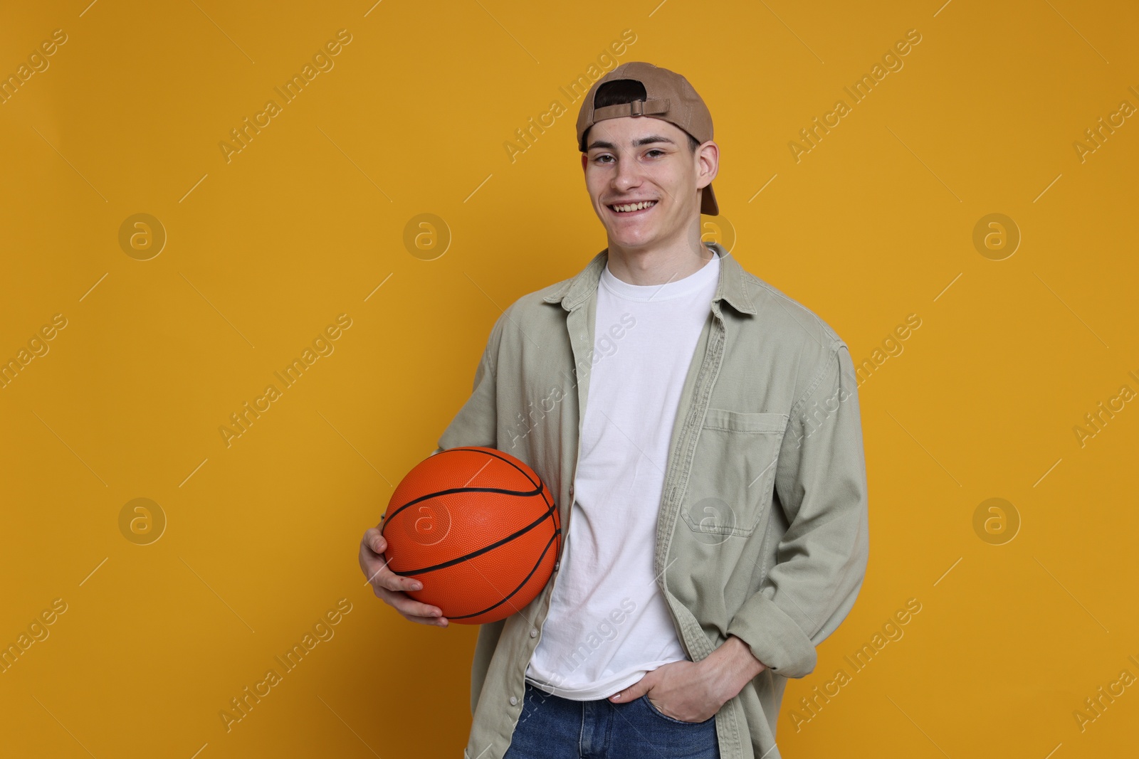 Photo of Student with basketball ball on orange background