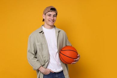 Photo of Student with basketball ball on orange background