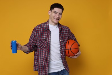 Photo of Student with basketball ball and can of drink on orange background