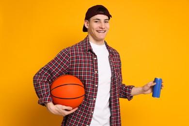 Photo of Student with basketball ball and can of drink on orange background