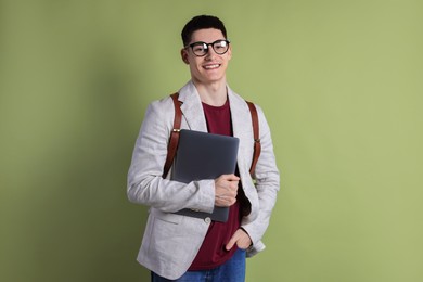 Photo of Student with laptop and backpack on olive background