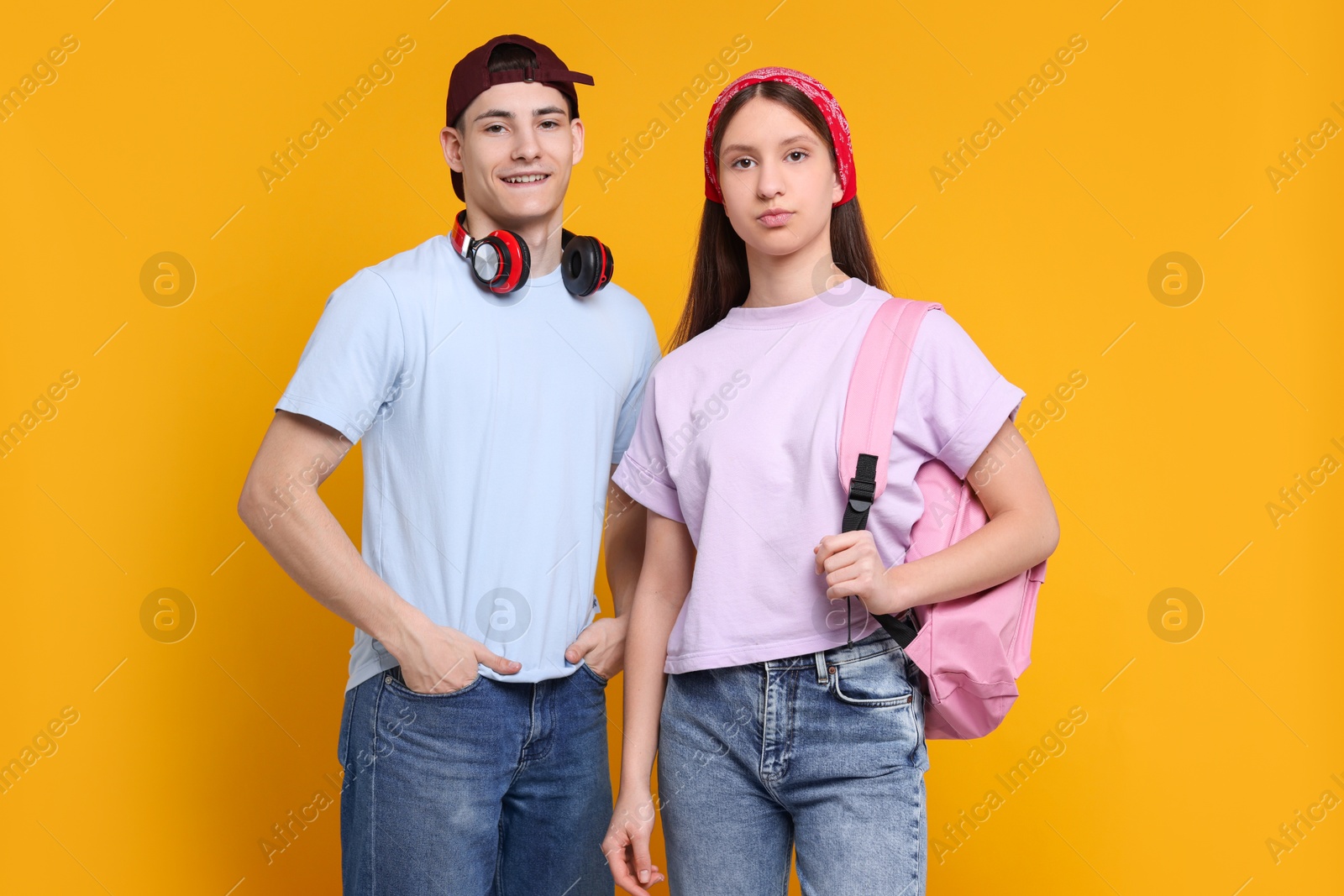 Photo of Portrait of stylish students on orange background