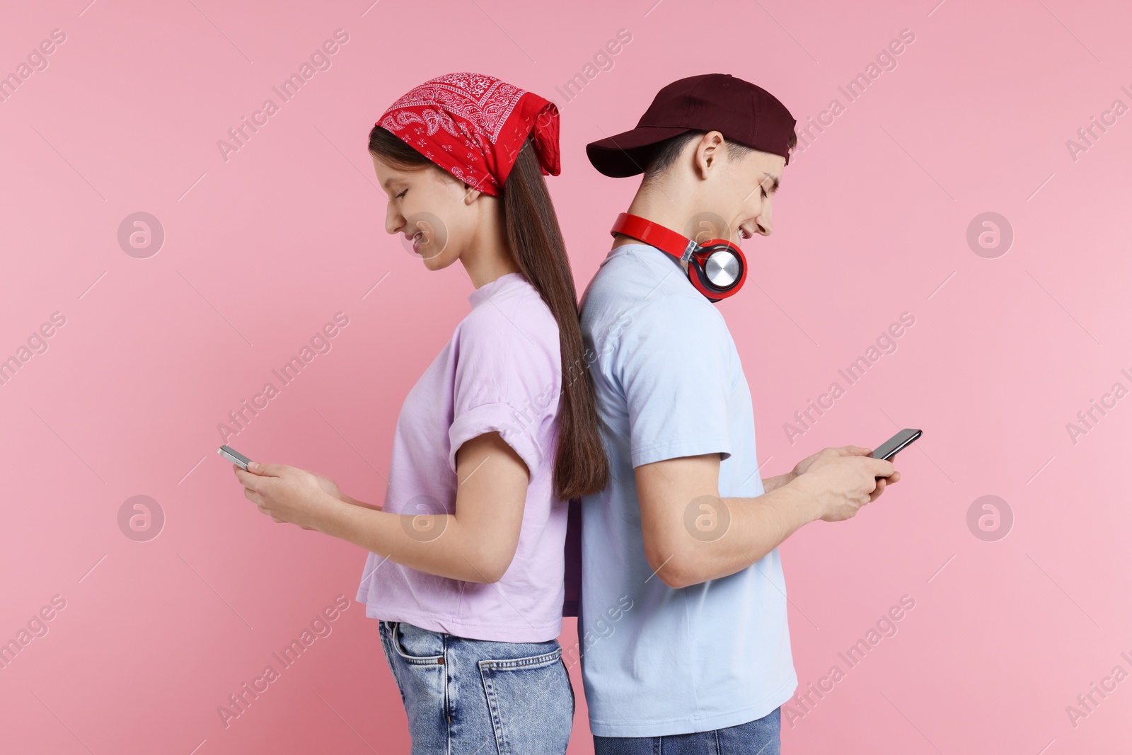 Photo of Portrait of students with smartphones on pink background