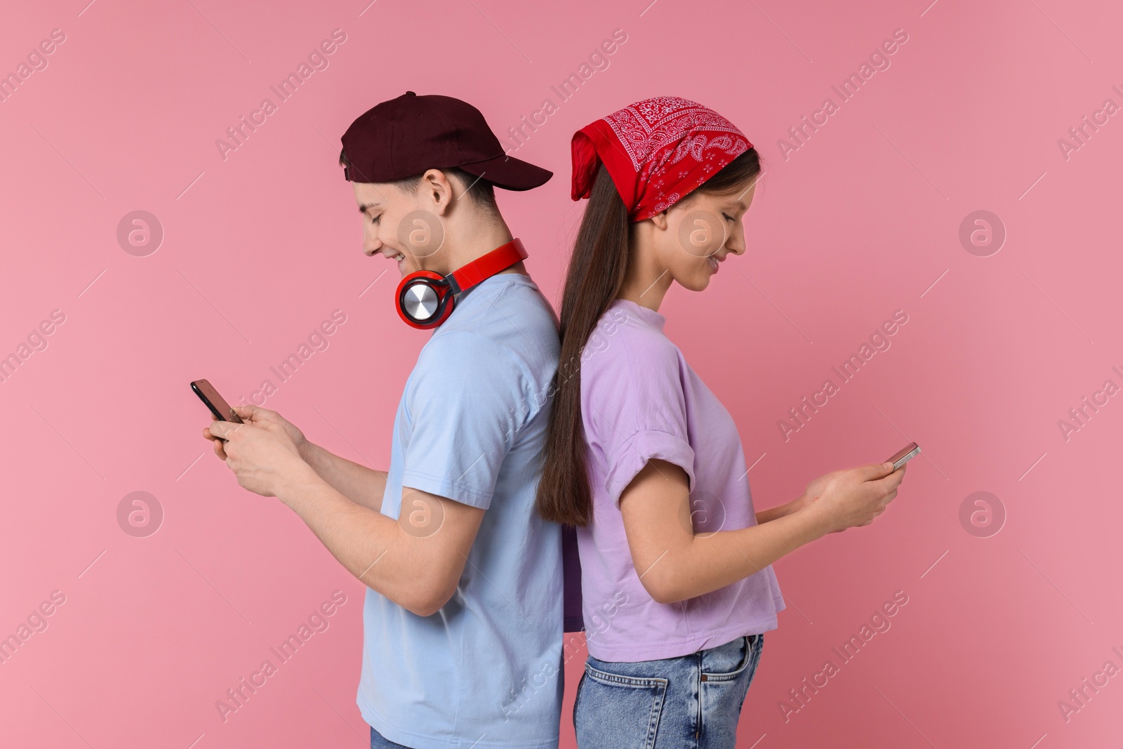 Photo of Portrait of students with smartphones on pink background