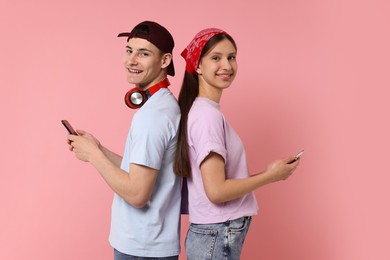 Portrait of students with smartphones on pink background