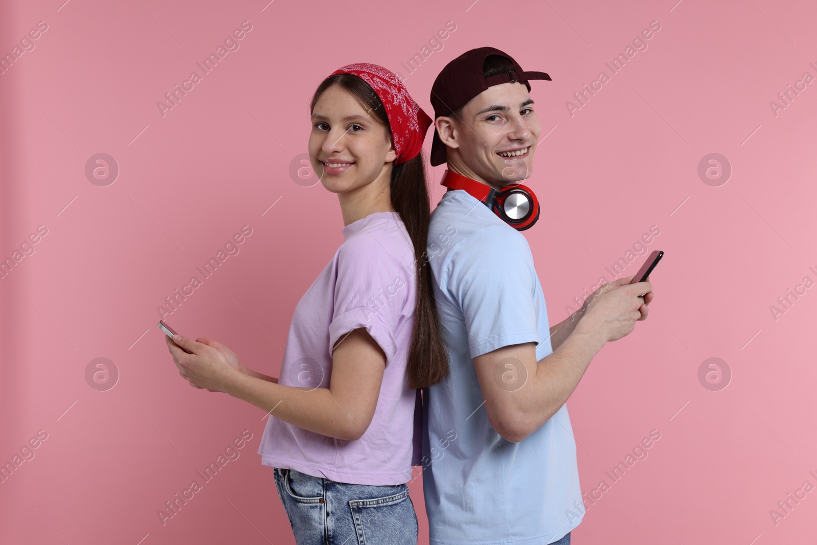 Photo of Portrait of students with smartphones on pink background