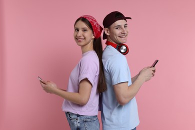 Portrait of students with smartphones on pink background