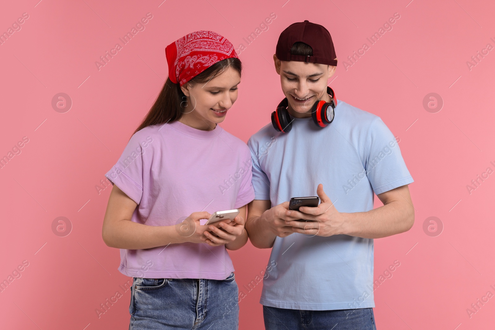 Photo of Portrait of students with smartphones on pink background