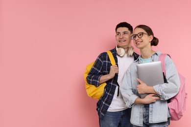 Students with backpacks and laptop on pink background, space for text