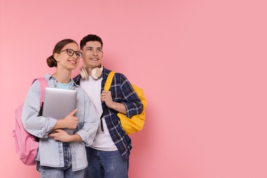 Students with backpacks and laptop on pink background, space for text