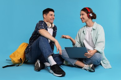 Photo of Students with laptop and headphones on light blue background