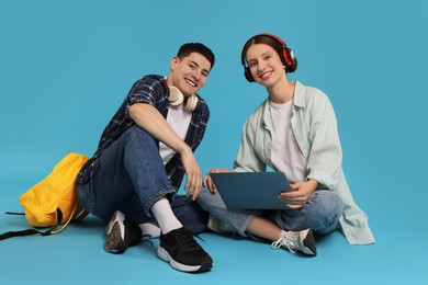 Photo of Students with laptop and headphones on light blue background