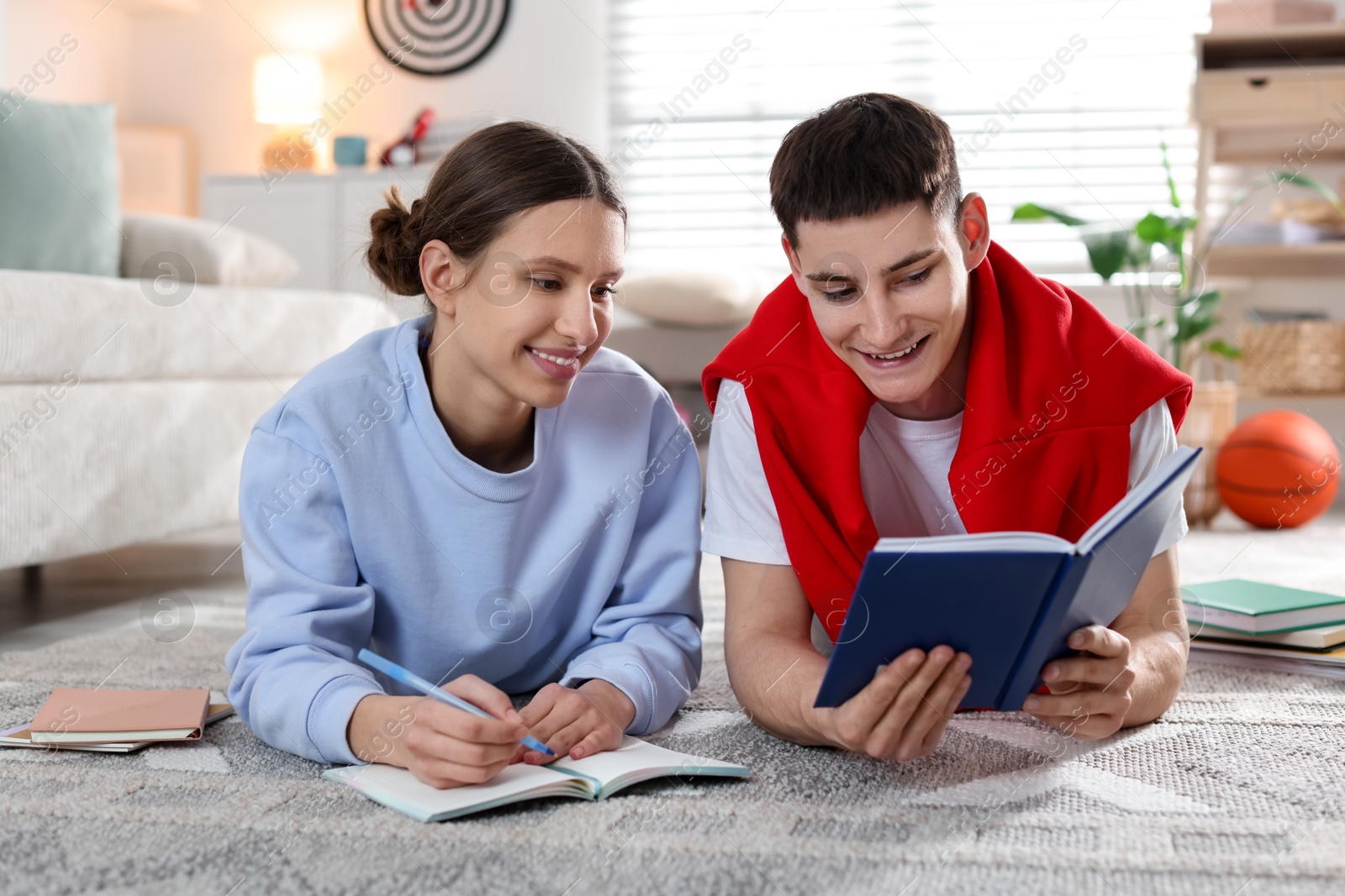 Photo of Students doing homework on floor at home