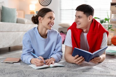 Students doing homework on floor at home