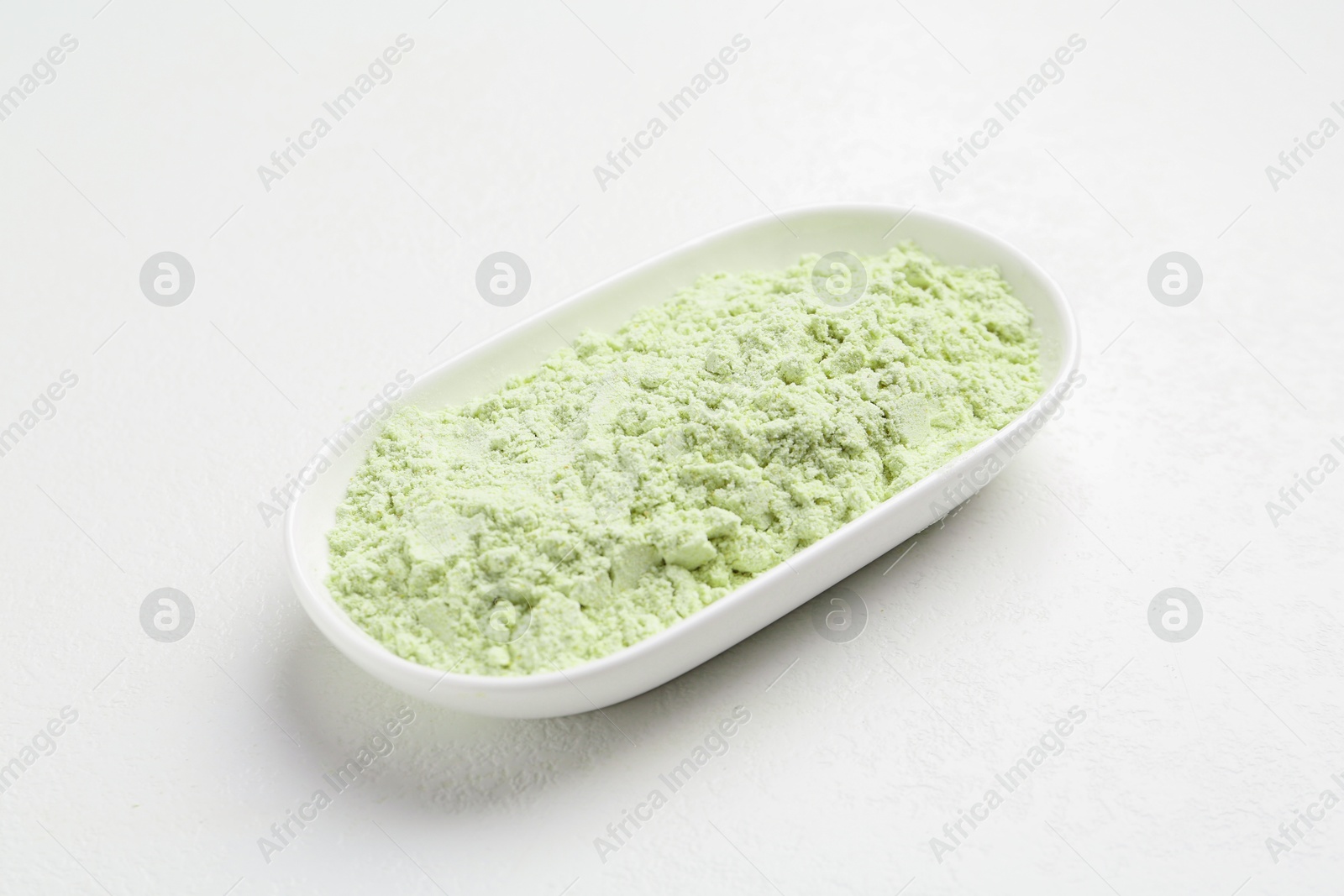 Photo of Dry wasabi powder on white textured table, closeup