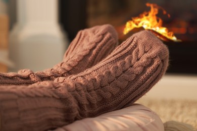 Photo of Woman in knitted socks resting at home, closeup