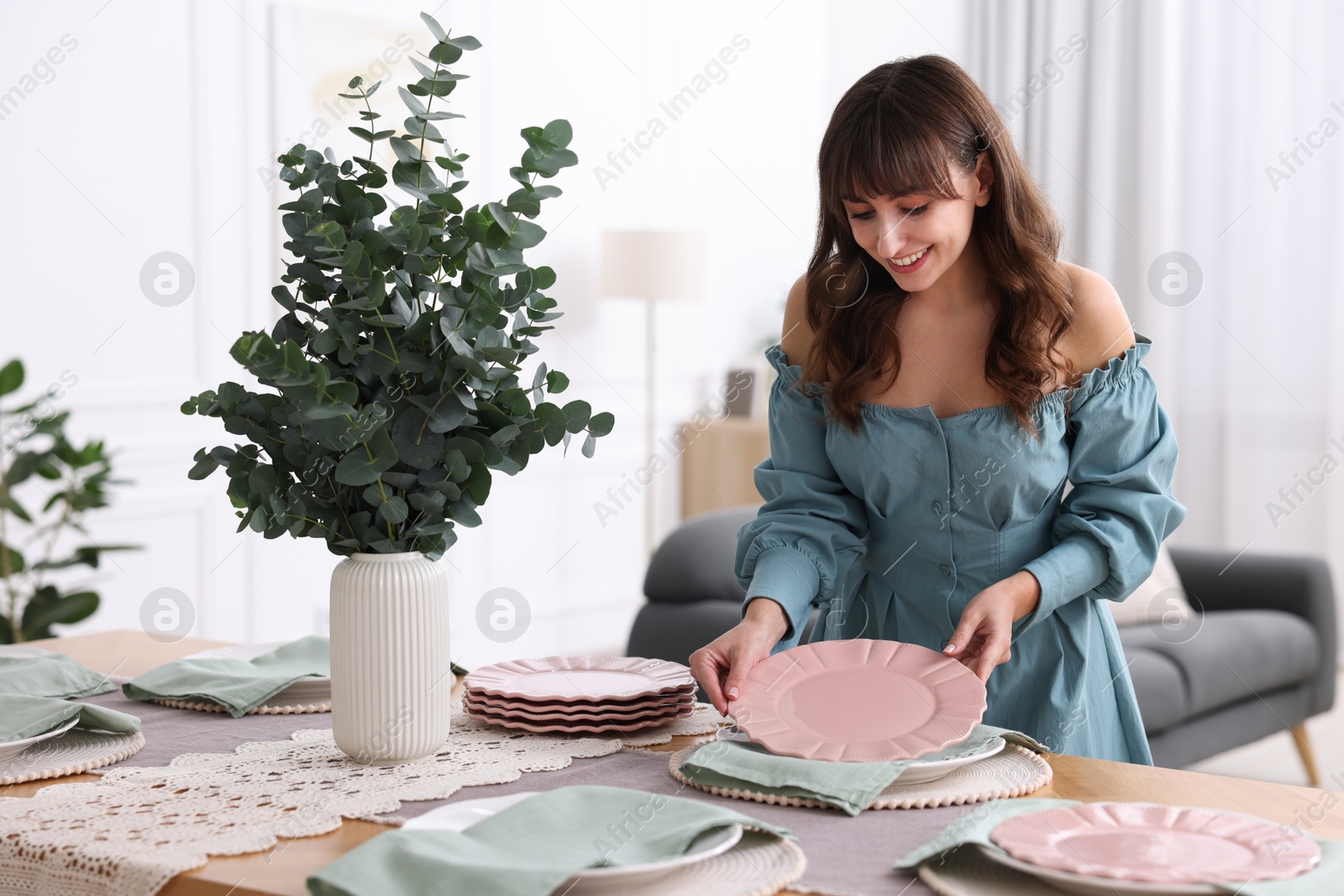 Photo of Woman setting table for dinner at home