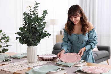 Photo of Woman setting table for dinner at home