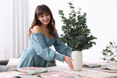 Photo of Woman setting table for dinner at home