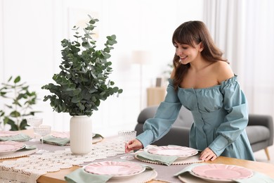 Photo of Woman setting table for dinner at home