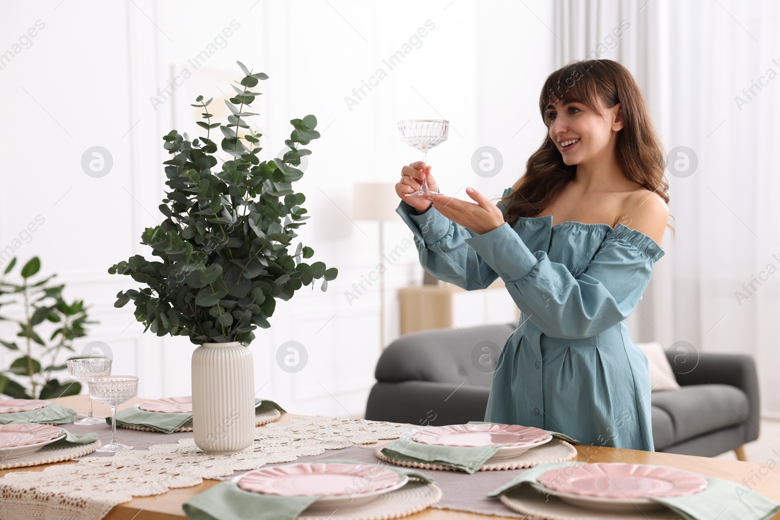 Photo of Woman setting table for dinner at home