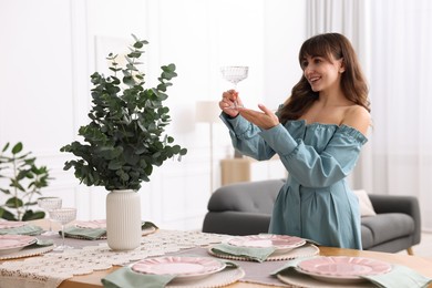 Photo of Woman setting table for dinner at home