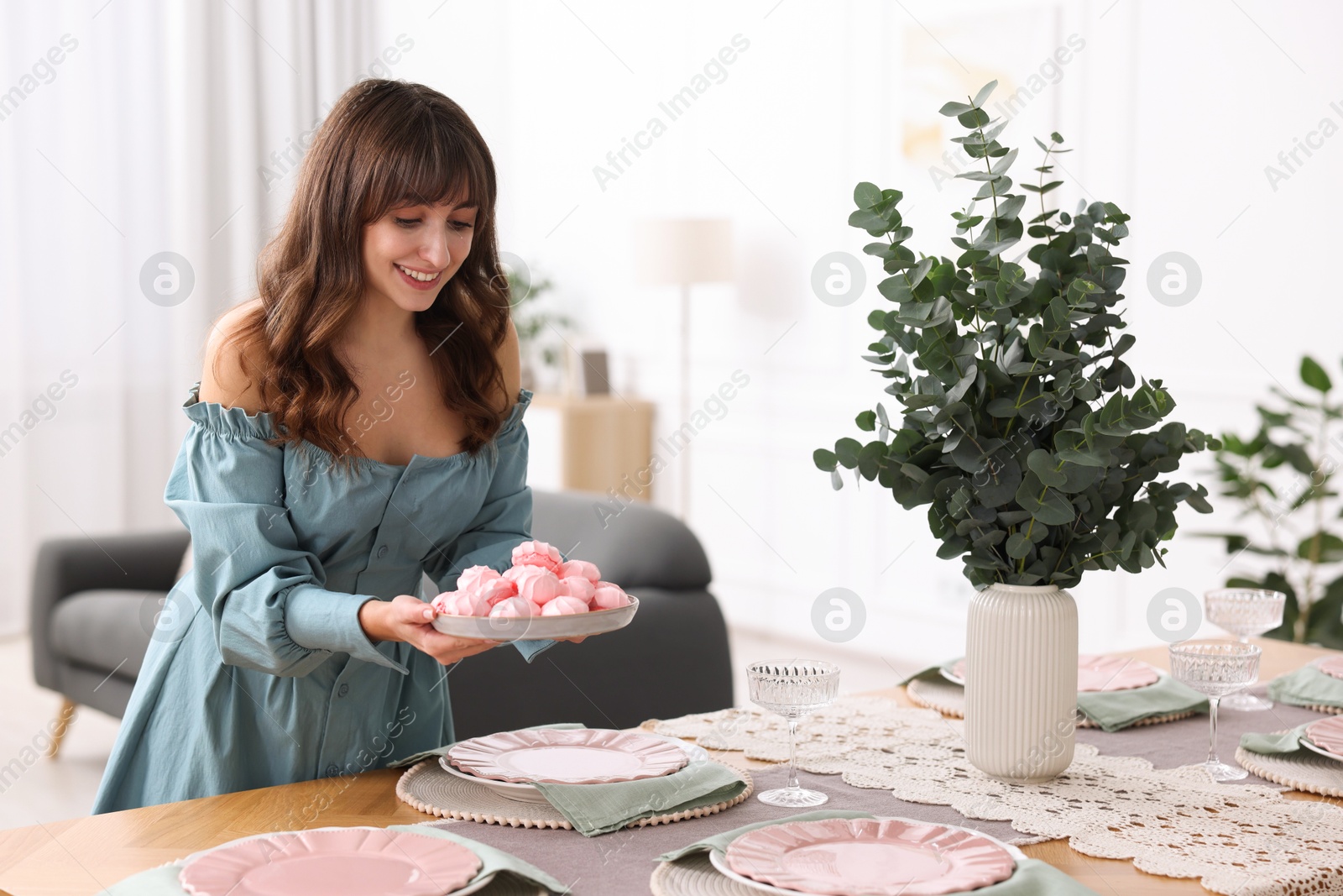 Photo of Woman setting table for dinner at home