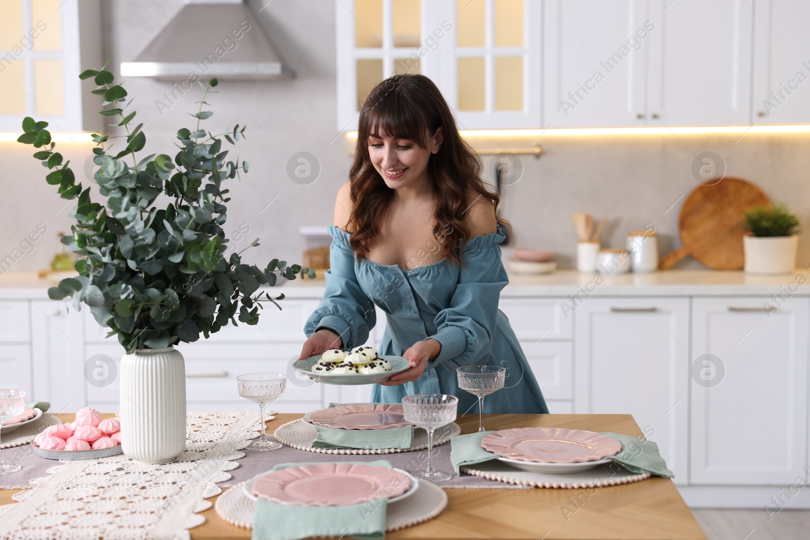 Photo of Woman setting table for dinner at home