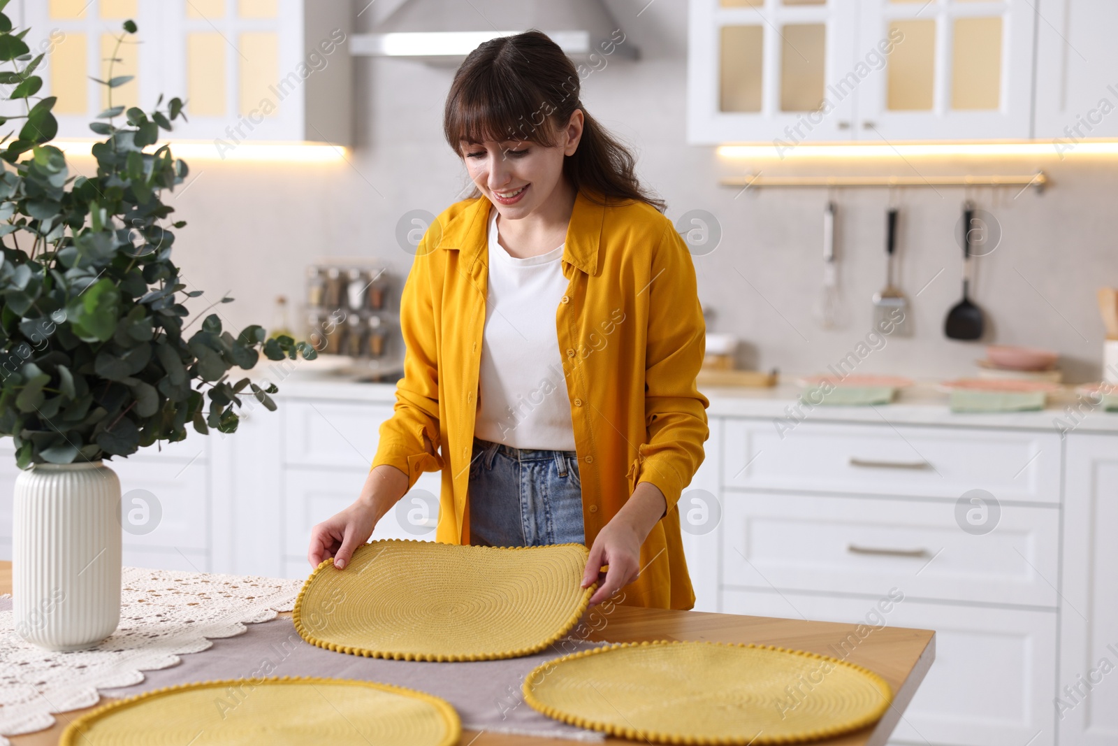 Photo of Woman setting table for dinner at home