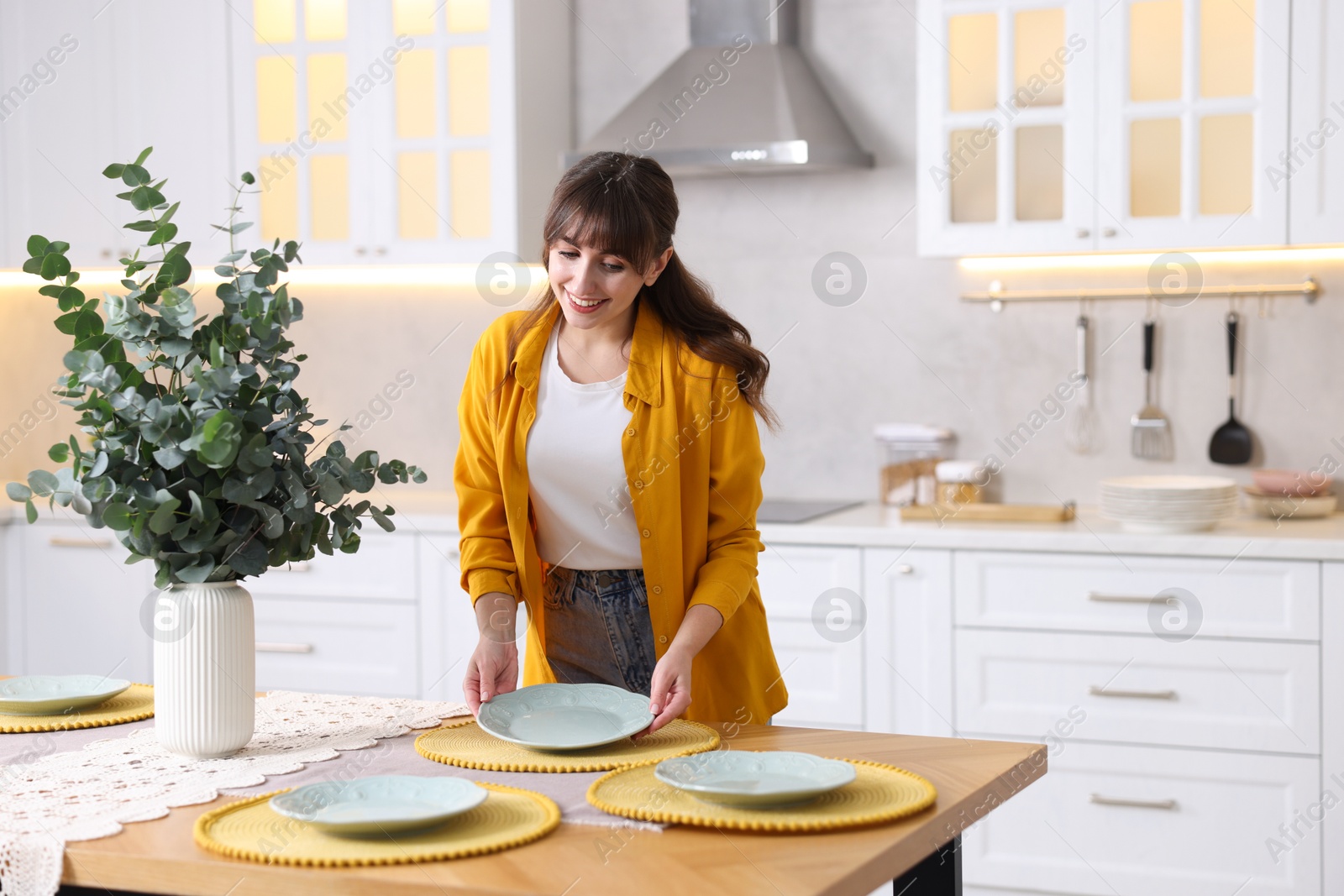 Photo of Woman setting table for dinner at home