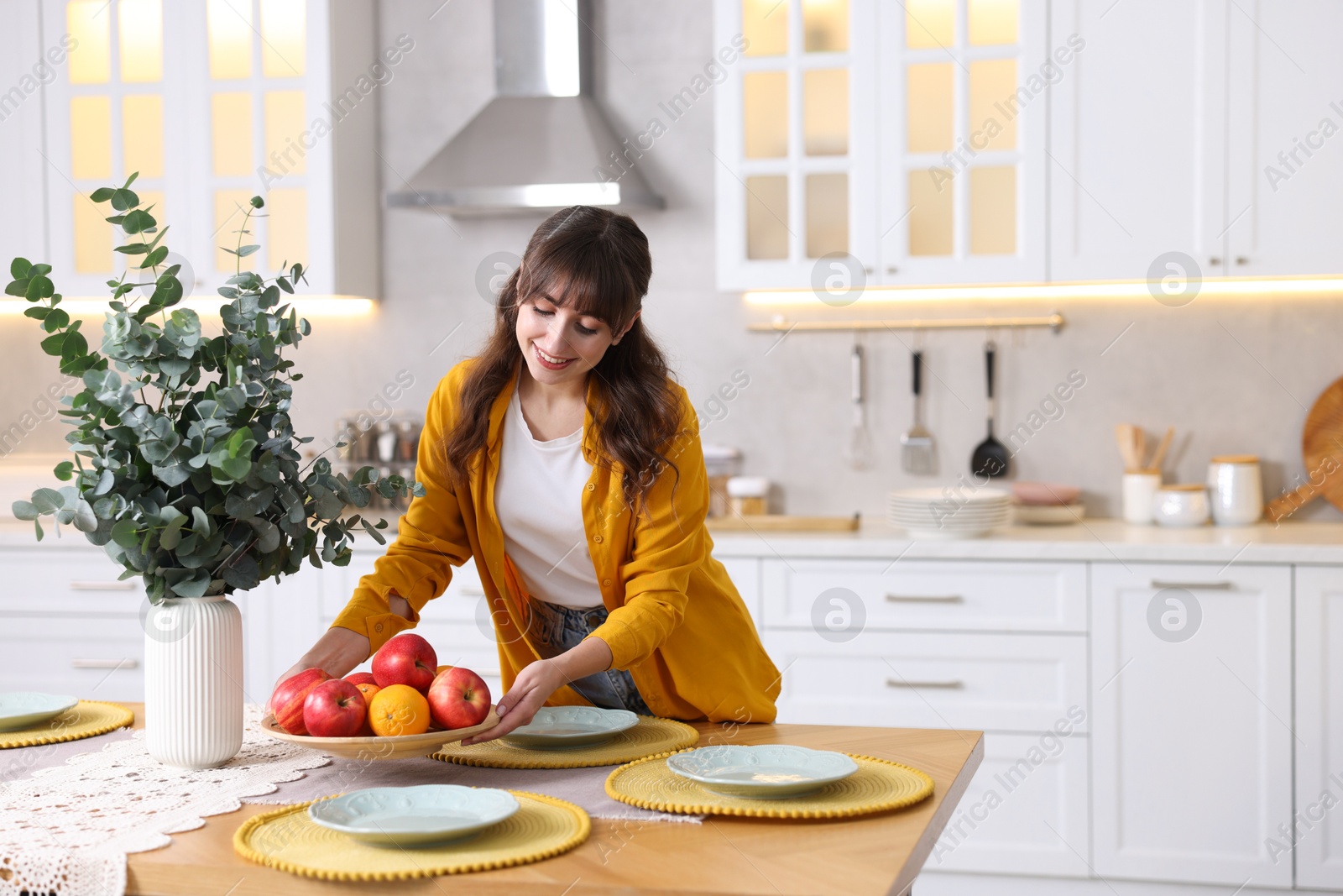 Photo of Woman setting table for dinner at home