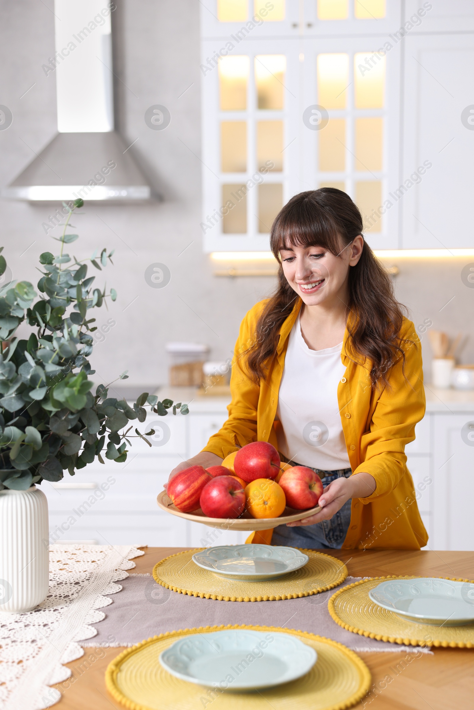 Photo of Woman setting table for dinner at home