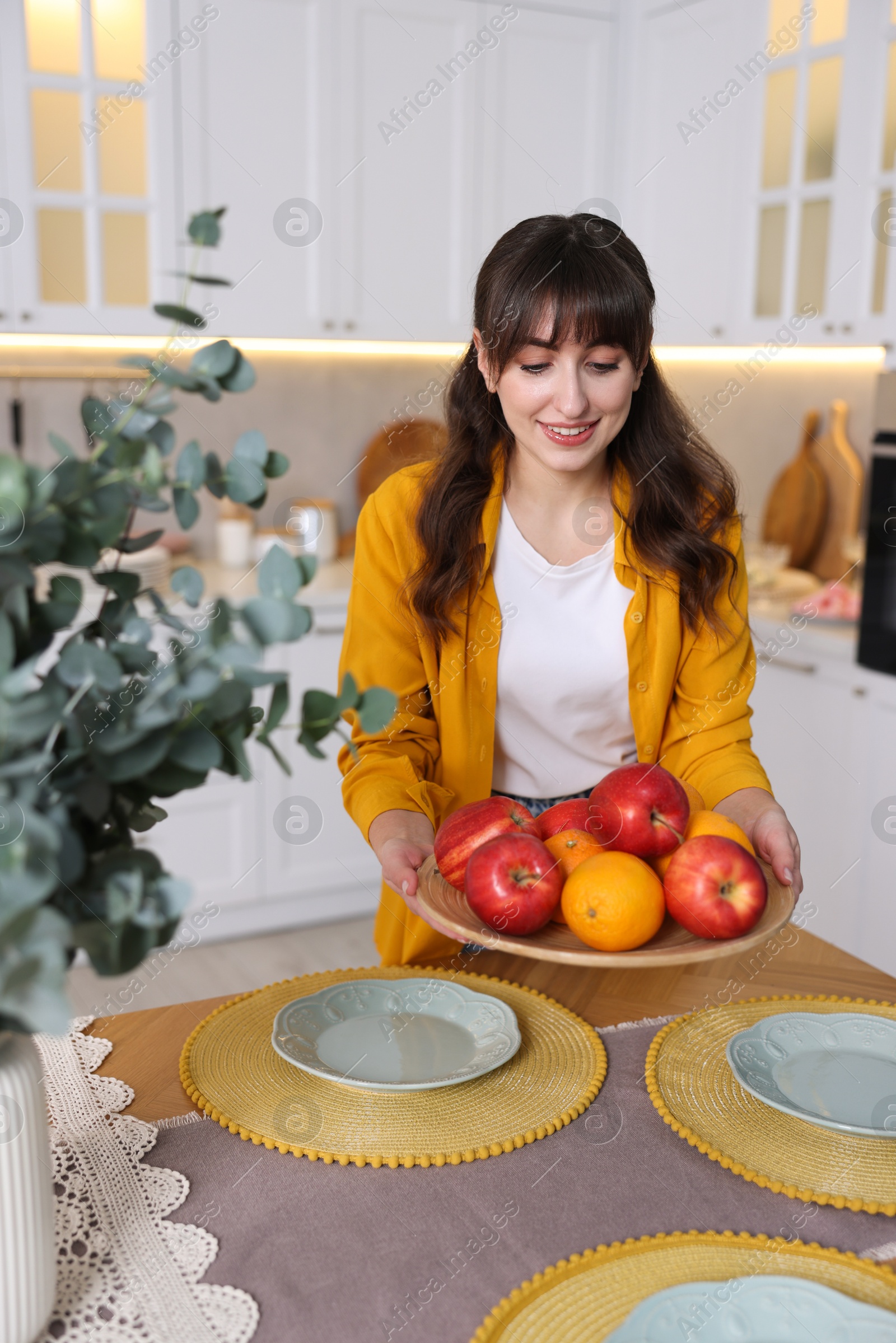 Photo of Woman setting table for dinner at home