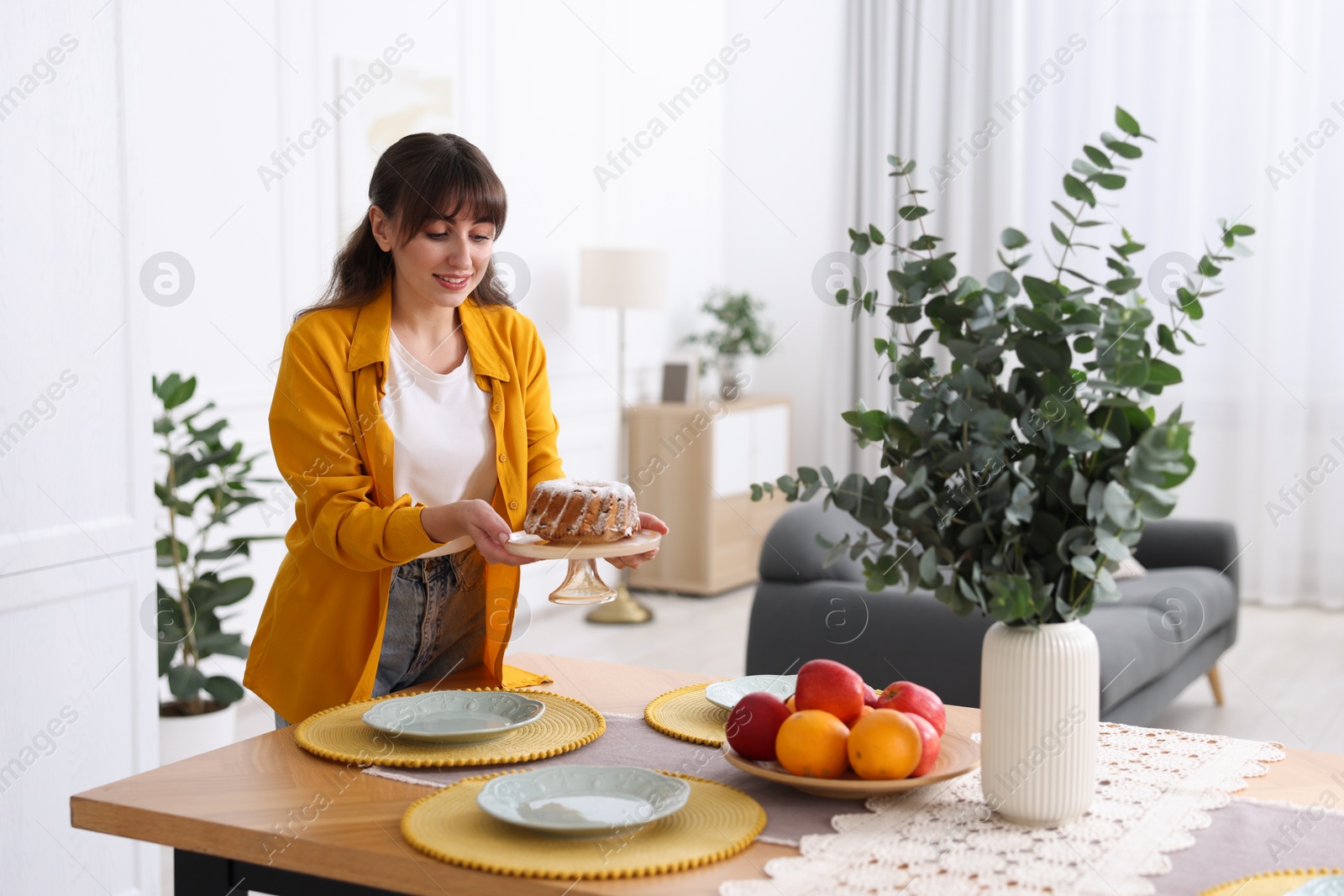 Photo of Woman setting table for dinner at home