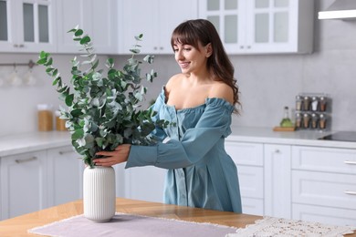 Woman setting table for dinner at home