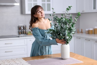 Woman setting table for dinner at home