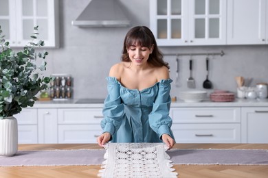 Woman setting table for dinner at home