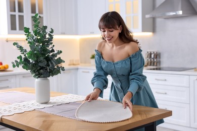 Woman setting table for dinner at home