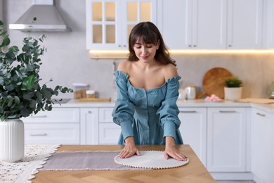 Photo of Woman setting table for dinner at home