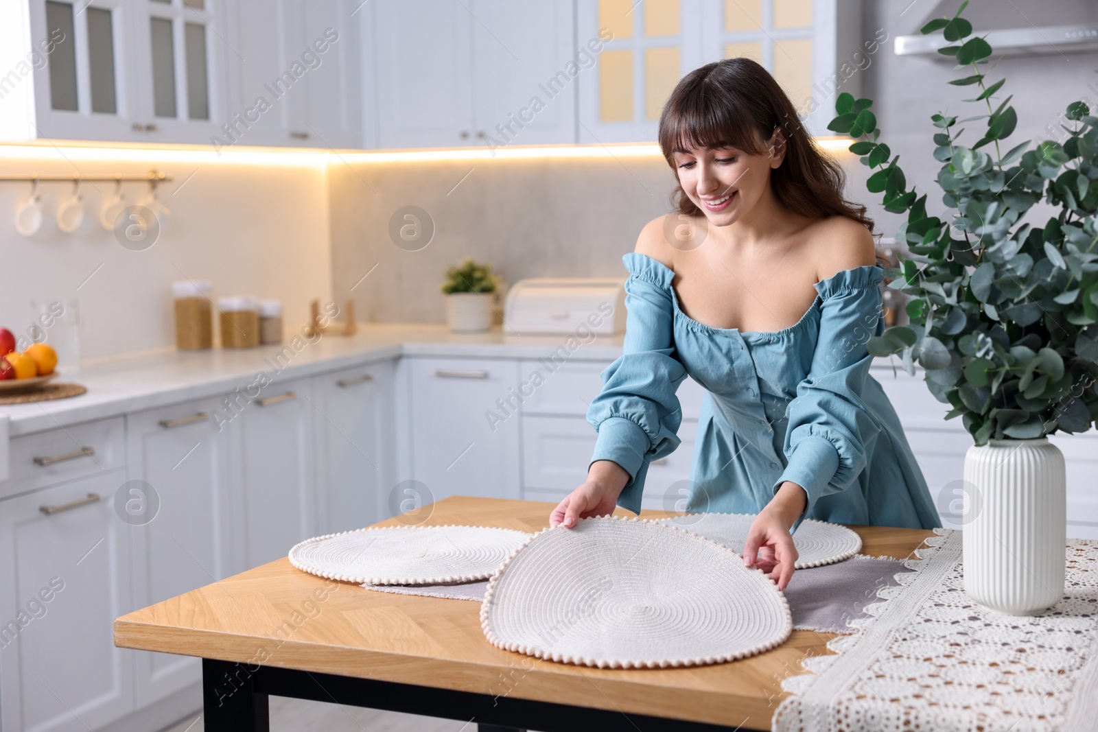 Photo of Woman setting table for dinner at home