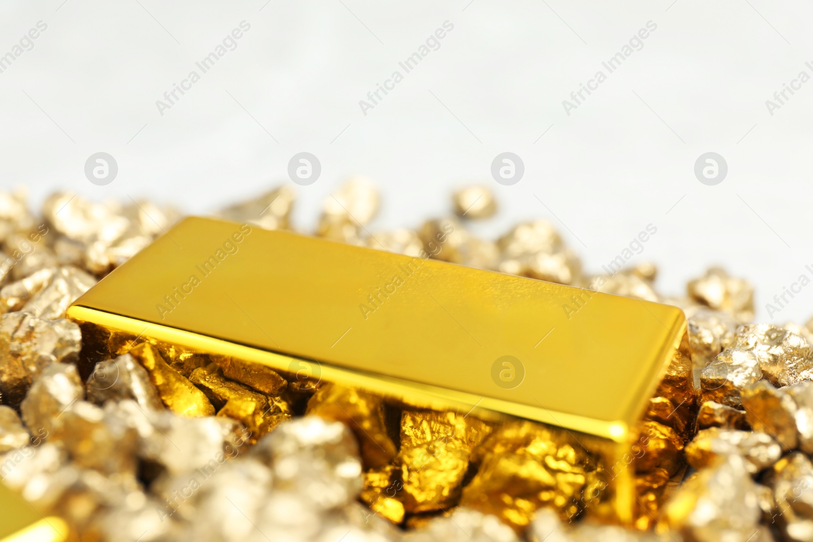 Photo of Gold nuggets and bar on table, closeup