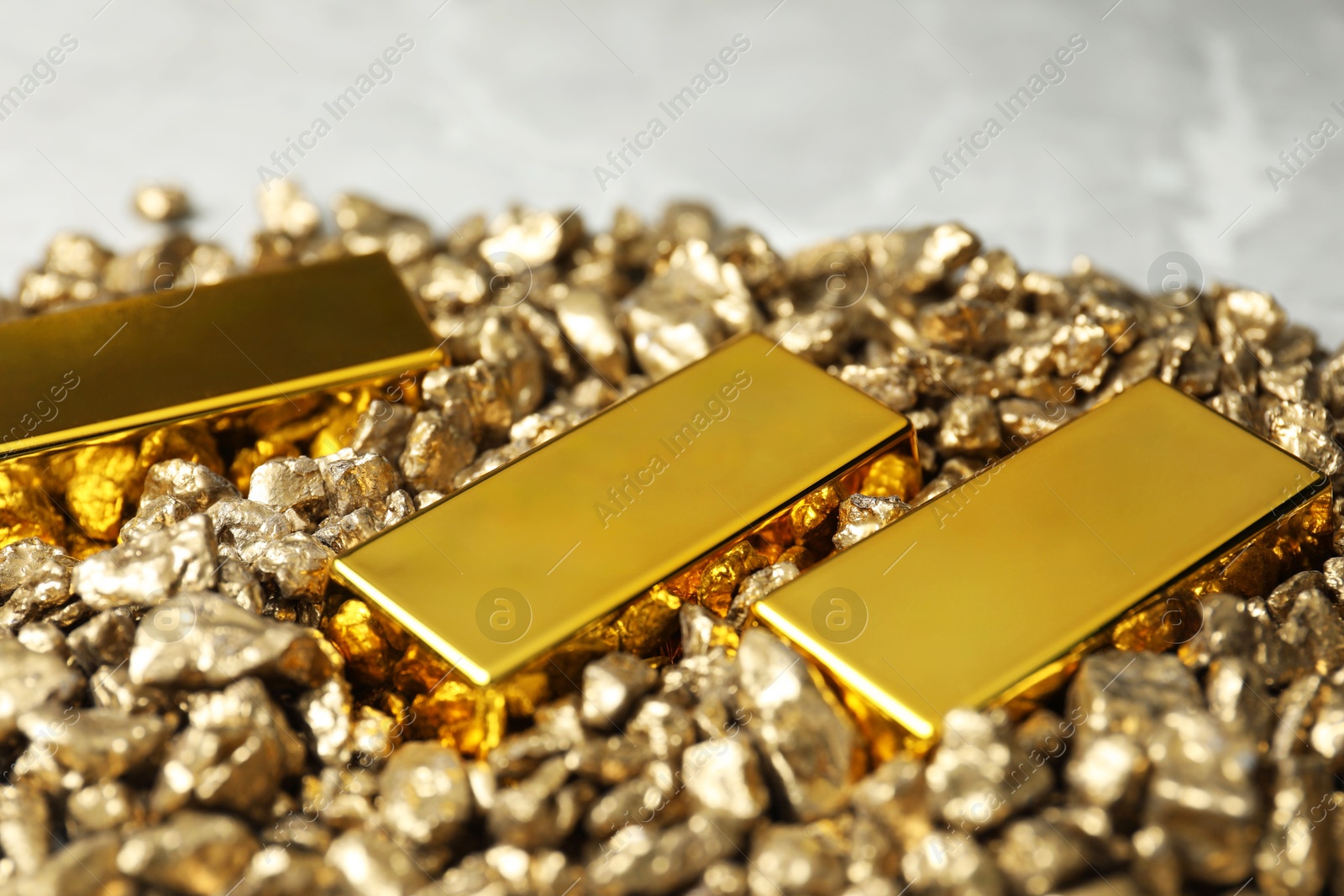 Photo of Gold nuggets and bars on table, closeup