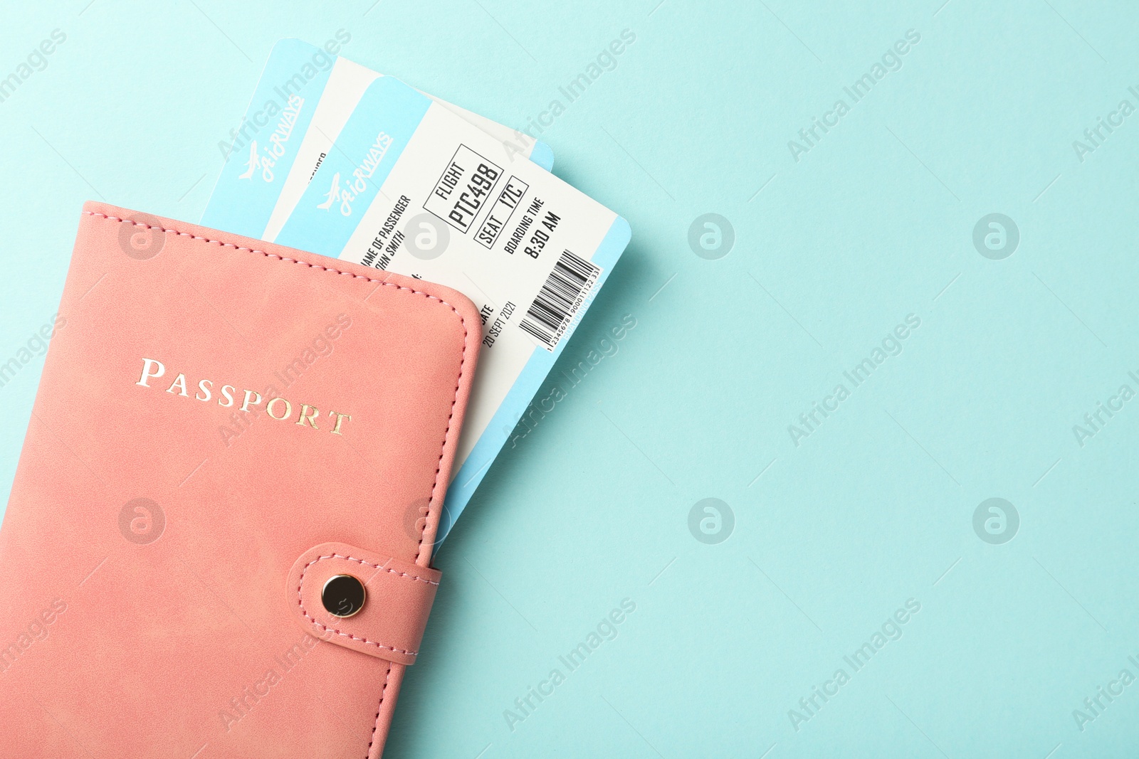 Photo of Passport with tickets on light blue background, top view. Space for text