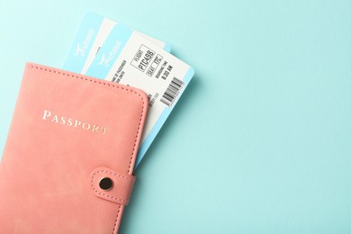 Photo of Passport with tickets on light blue background, top view. Space for text