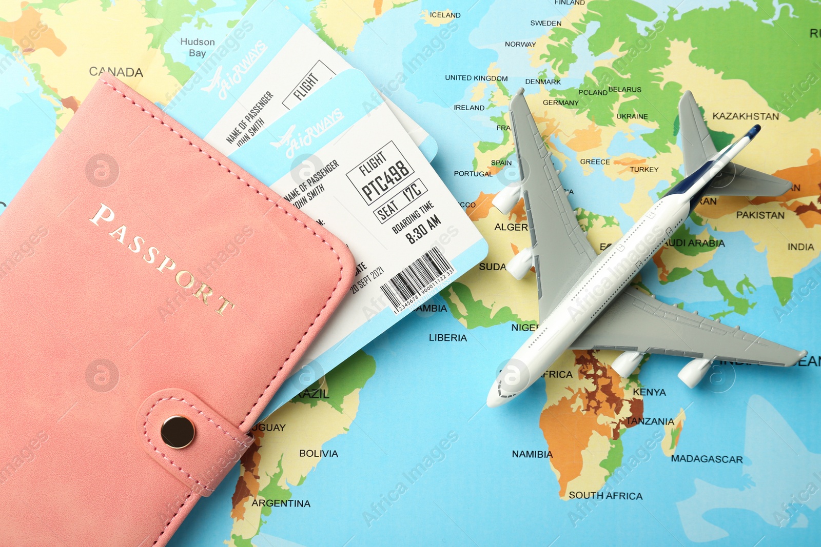 Photo of Passport with tickets and plane model on world map, flat lay